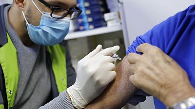 Un pharmacien administre un vaccin contre la grippe dans une pharmacie parisienne en octobre 2020.