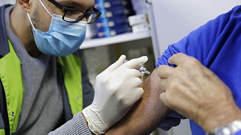 A pharmacist administers a flu vaccine in a Paris drugstore in October 2020.