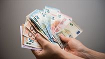 Uma pessoa com várias notas de euro na mão