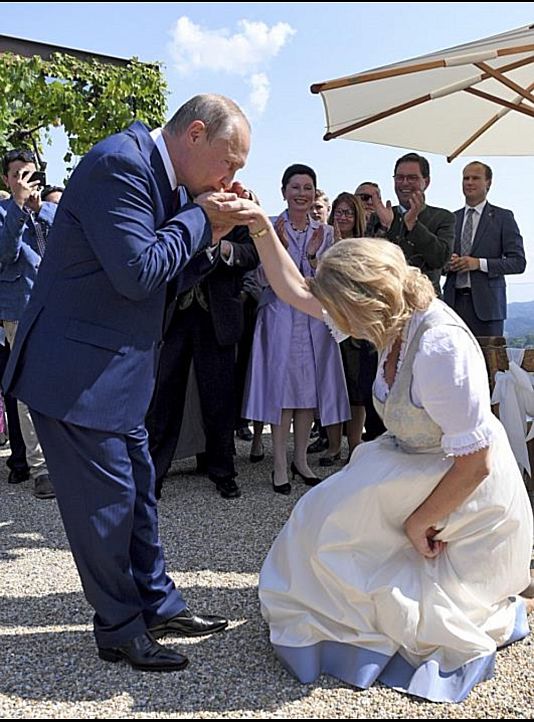 Karin Kneissl osztrák külügyminiszter pukedlizve meghajol Vlagyimir Putyin orosz elnök előtt, 2018 augusztusában