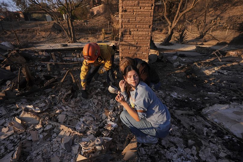 Une femme fouille les décombres de sa maison avec le capitaine des pompiers de Glendale, Chris Jernegan, le 11 janvier 2025.