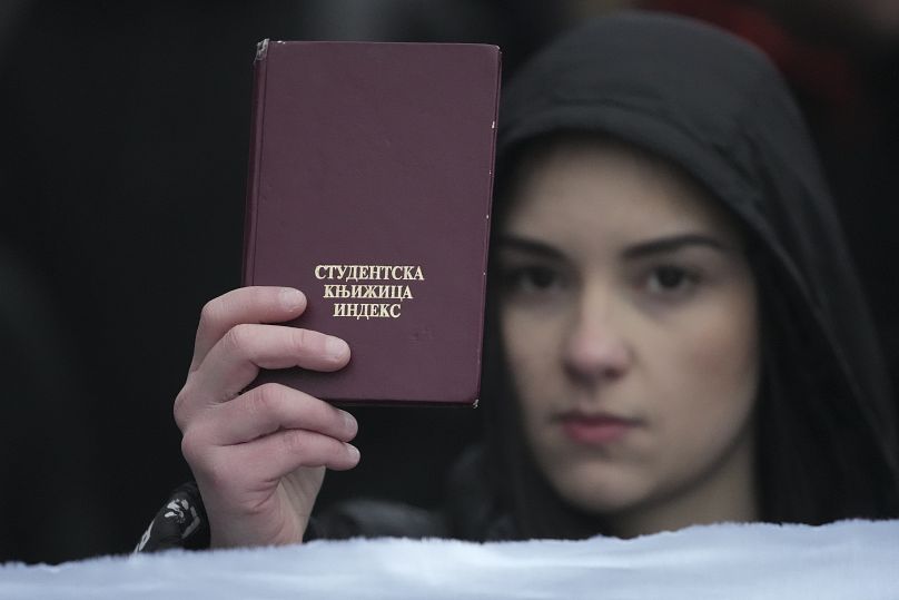 Девушка держит свой студенческий билет на акции протеста против нарушения гражданских прав перед Конституционным судом в Белграде, 12 января 2025 г.
