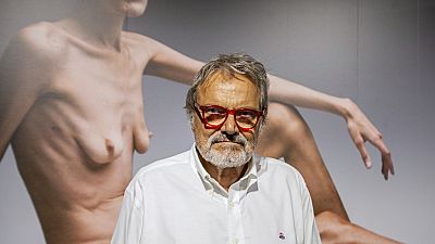 El fotógrafo Oliviero Toscani, junto a una de sus obras.