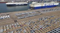 Veículos e camiões para exportação aguardam transporte num porto em Yantai, na província de Shandong, no leste da China