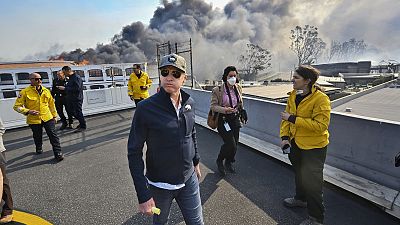 Il governatore della California Gavin Newsom esamina i danni causati dall'incendio di Palisades, mercoledì 8 gennaio 2025, a Pacific Palisades, in California. 