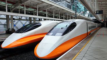 Two modern high-speed trains in a train station Two modern high-speed trains in a train station