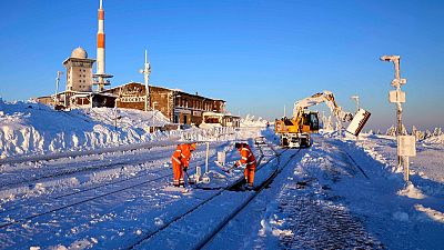 Railroad workers clear the tracks from snow on northern Germany's 1,142-meter high 'Brocken' at the Harz mountains near Schierke, Germany, Monday, Jan. 13, 2025.