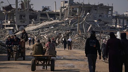 Palestinesi trasportano farina donata dalle Nazioni Unite a Khan Younis, nel centro della Striscia di Gaza, 14 dicembre 2024