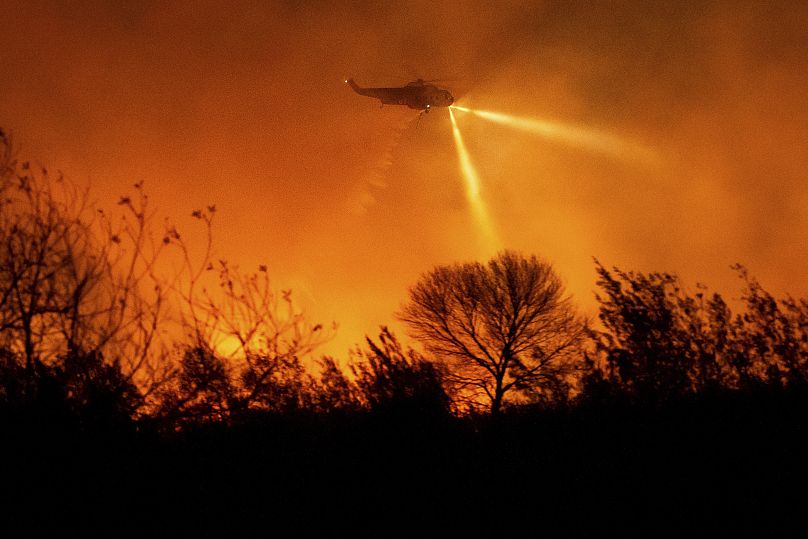 A helicopter drops water while fighting the Auto Fire in Ventura County, Calif. - Monday 13 January 2025