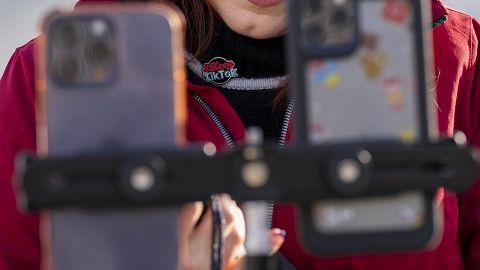 Wearing a button in support of TikTok, Tiffany Cianci, who says she is a "long-form educational content creator," livestreams to TikTok outside the Supreme Court, Friday, Jan.