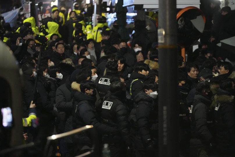 Police officers try to enter as the members of the ruling People Power Party try to block them in front of the gate of the presidential residence in Seoul, Jan. 15, 2025