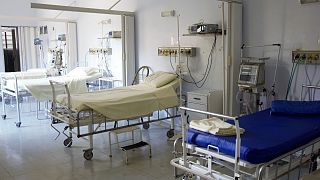 Empty hospital beds are shown.