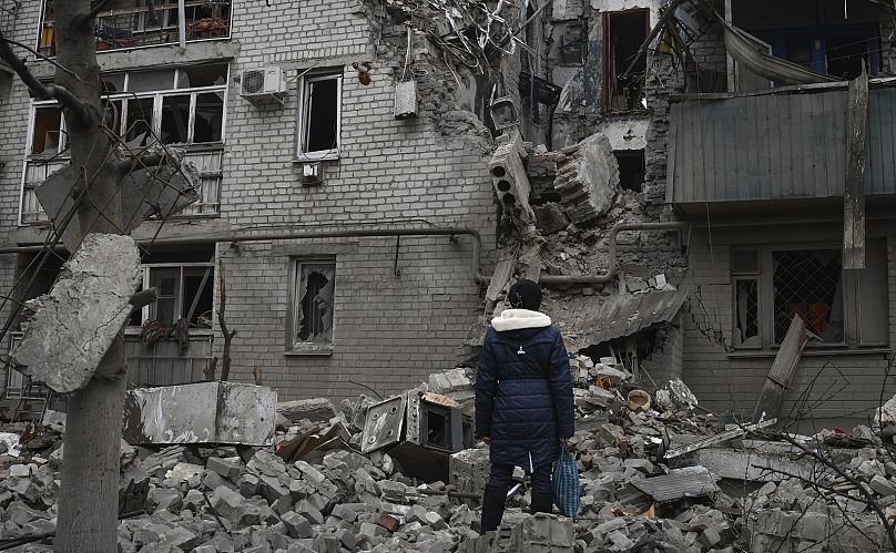 Una mujer entre los escombros de la casa destruida tras un ataque aéreo ruso en Chasiv Yar, Ucrania, el domingo 27 de noviembre de 2022.