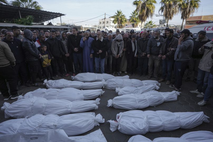 Mourners pray next to the bodies of Palestinians who were killed in the Israeli bombardment of the Gaza Strip at Al-Aqsa Hospital in Deir al-Balah, Wednesday, Jan. 15, 2025. 