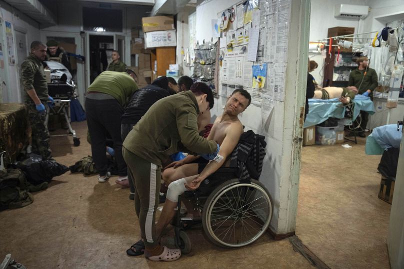 Des médecins militaires donnent les premiers soins à des soldats ukrainiens blessés près de Bakhmut, en Ukraine, le jeudi 25 janvier 2024.