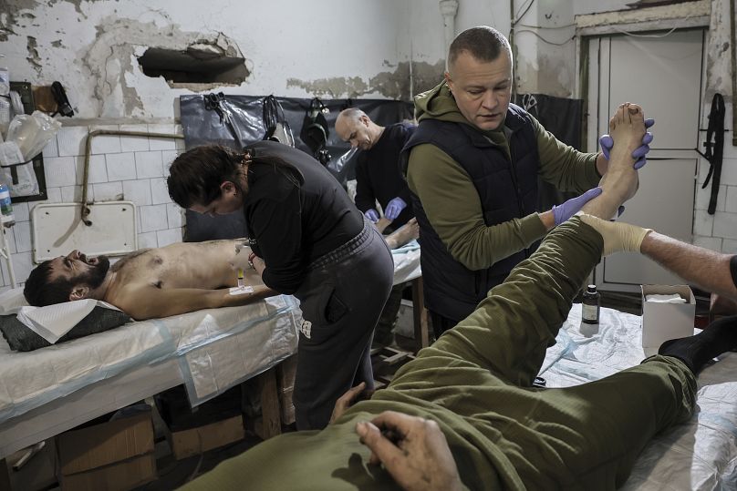 Des médecins militaires donnent les premiers soins à un soldat ukrainien blessé dans la région de Donetsk, en Ukraine, le lundi 16 décembre 2024.