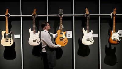 An art handler displays the 1959 Gibson Les Paul 'The Yardburst' at Christie's London on 14 January 2025, ahead of the pre-sale exhibition.