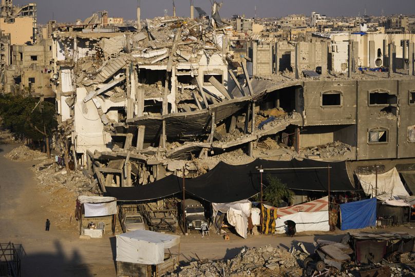فلسطينيون يسيرون وسط الدمار الذي خلفته الغارات الإسرائيلية على خان يونس جنوب قطاع غزة 7 كانون الثاني يناير 2025
