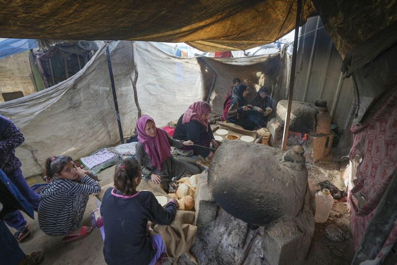 نساء يخبزن في مخيم خيام للنازحين الفلسطينيين.