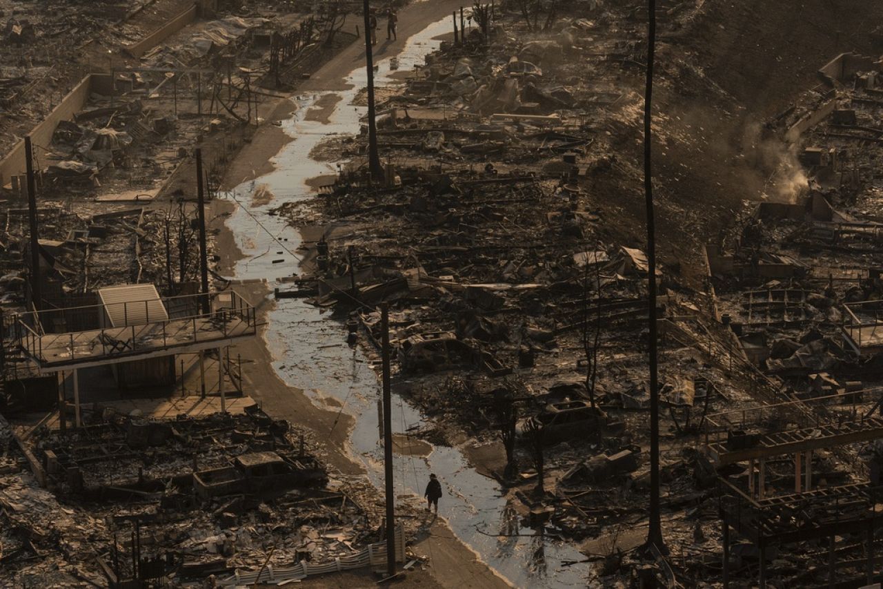 A person walks amid the destruction left behind by the Palisades Fire in the Pacific Palisades neighborhood of Los Angeles, 9 January 2025.