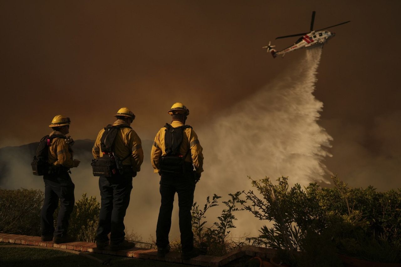 Water is dropped by helicopter on the Palisades Fire in Mandeville Canyon, Jan. 11, 2025, in Los Angeles