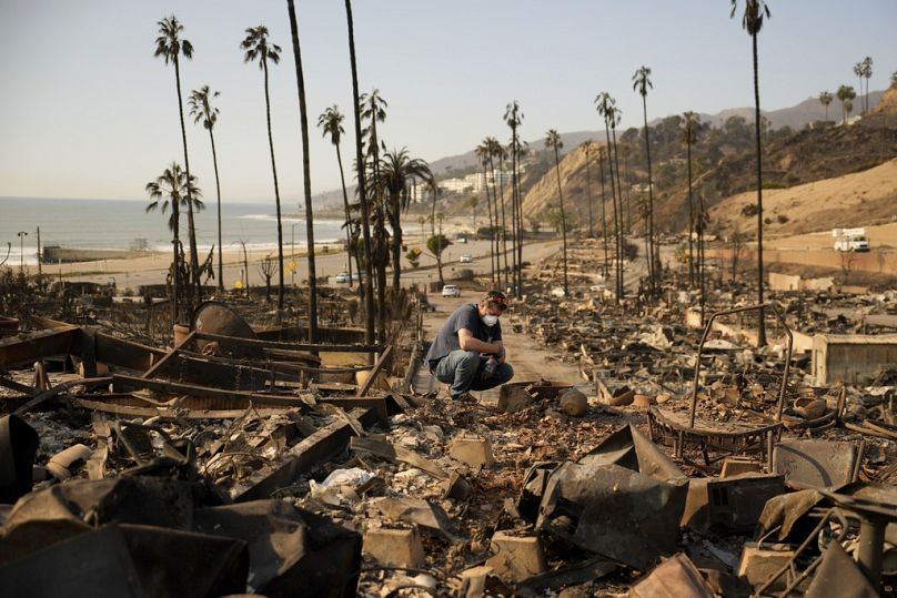 Kevin Marshall sifts through his mother's fire-ravaged property in the the Palisades Fire in the Pacific Palisades neighborhood of Los Angeles, Saturday, Jan. 11, 2025.