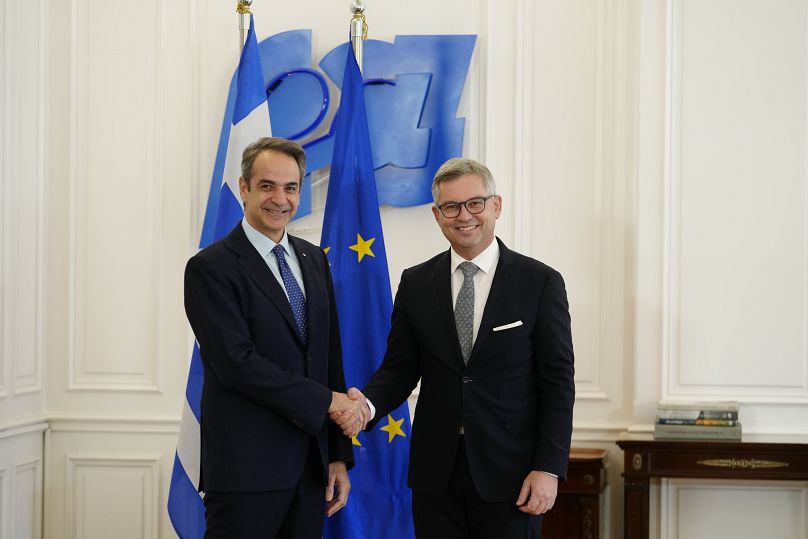 The EU's commissioner for migration Magnus Brunner, right, shakes hands with Greece's Prime Minister Kyriakos Mitsotakis in Athens, 16 January, 2025