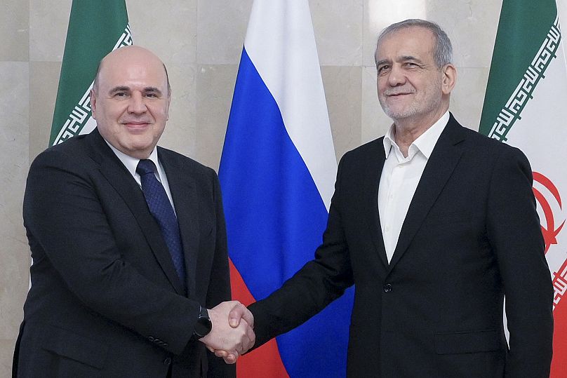 رئيس الوزراء الروسي ميخائيل ميشوستين، إلى اليسار، والرئيس الإيراني مسعود بيزشكيان يقفان لالتقاط صورة قبل محادثاتهما في موسكو، روسيا، الجمعة 17 يناير/كانون الثاني 2025
