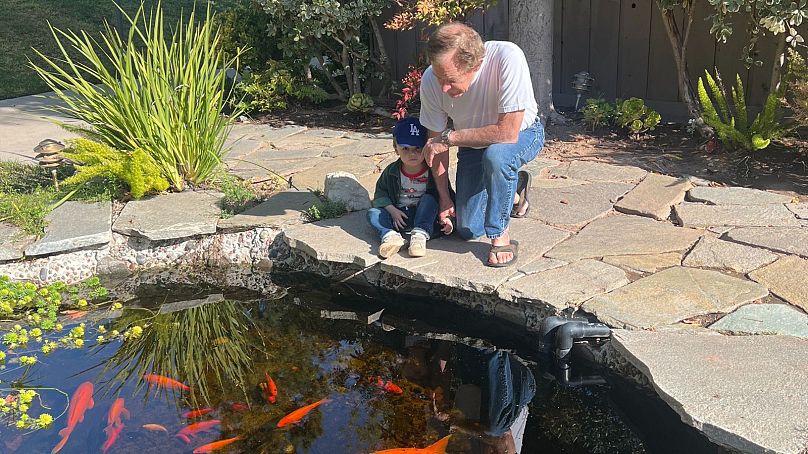 Craig with grandson Henry at the couple's condominium building's koi carp pond.