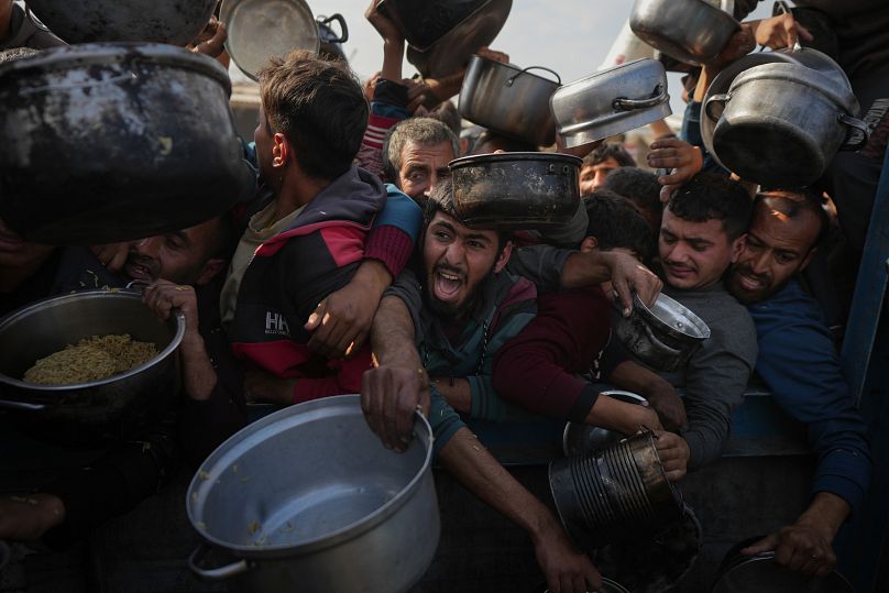 فلسطينيون يكافحون للحصول على الطعام في مركز توزيع في خان يونس، قطاع غزة، 9 يناير/كانون الثاني 2025