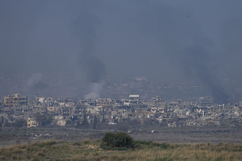 الدخان يتصاعد خلف المباني المدمرة جراء القصف الإسرائيلي داخل قطاع غزة من جنوب إسرائيل، الخميس، 16 يناير/كانون الثاني 2025