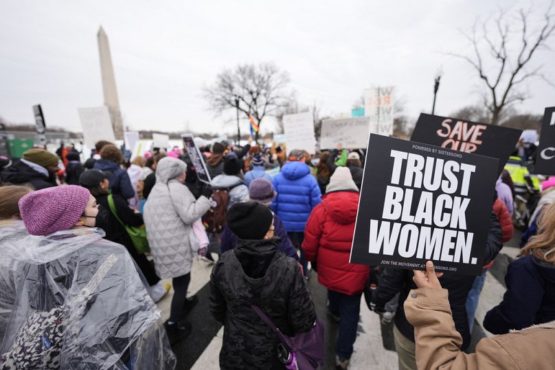 People march past the Washington Monument during the People's March, Saturday, Jan. 18, 2025, in Washington. (AP Photo/Mike Stewart)