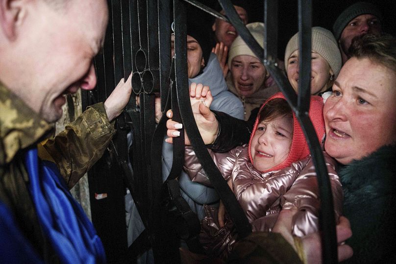 Un militar ucraniano llora al ver a su hija después de regresar del cautiverio durante un intercambio de prisioneros de guerra entre Rusia y Ucrania, el 30 de diciembre