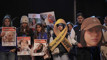 People hold hostages' portraits on stage during a rally in Paris, 18 January, 2025