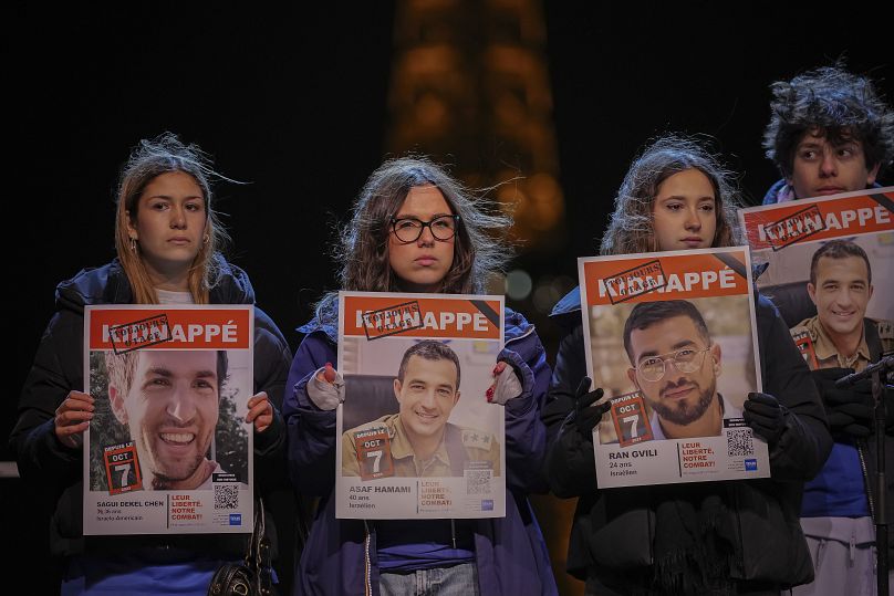 Paris'teki miting sırasında protestocular rehinelerin portrelerini tutuyor