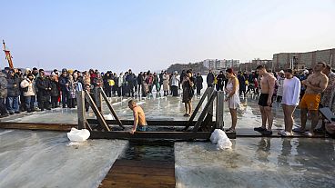 People plunge in icy water to celebrate the Orthodox Epiphany near the St. Serafimovsky Monastery on Russian Island in Russian far east port Vladivostok, Russia, Sunday, Jan. 