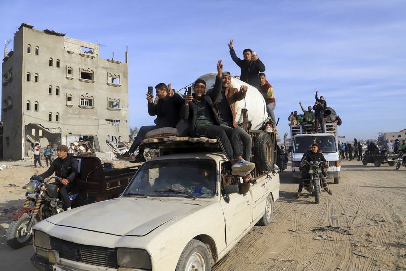 نازحون فلسطينيون يرفعون إشارة النصر أثناء عودتهم إلى رفح، قطاع غزة، الأحد، 19 يناير/كانون الثاني 2025