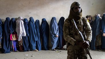 A Taliban fighter stands guard as women wait to receive food rations distributed by a humanitarian aid group in Kabul, 23 May, 2023 A Taliban fighter stands guard as women wait to receive food rations distributed by a humanitarian aid group in Kabul, 23 May, 2023
