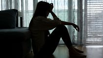 A woman sits with her head in her hands.