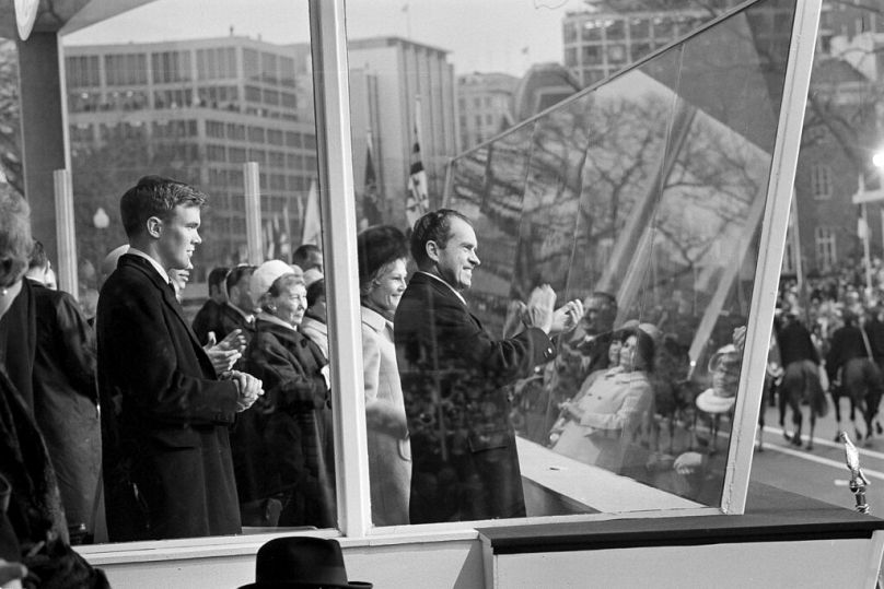 Nixon applauds a passing unit during the inaugural parade in Washington, D.C., Jan. 20, 1969