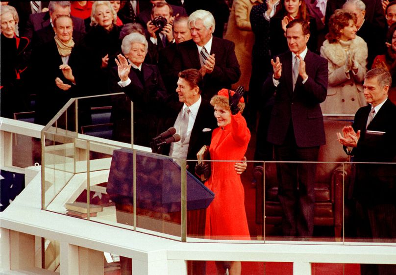 U.S. President Ronald Reagan and his wife, first lady Nancy Reagan, wave to the crowd on the west front of the Capitol building in Washington, D.C