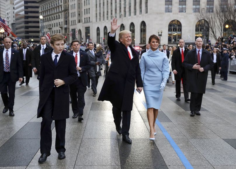 FILE - President Donald Trump waves as he walks with first lady Melania Trump and their son Barron, walk during the inauguration parade on Pennsylvania Avenue in Washington