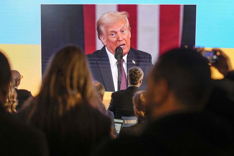 People watch the inauguration of Donald Trump on screens at the Ukraine house alongside the World Economic Forum in Davos, Switzerland, Monday, Jan. 20, 2025