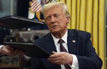 US President Donald Trump signs executive orders in the Oval Office of the White House, Monday, Jan. 20, 2025, in Washington, D.C.