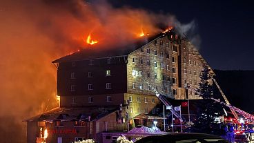 Firefighters work to extinguish a fire in a hotel at a ski resort in Turkey