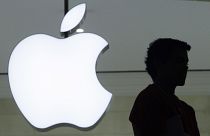 A person stands near the Apple logo at the company's new store in Grand Central Terminal, Wednesday, Dec. 7, 2011 in New York. 