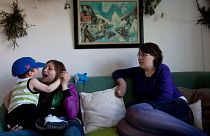 In this July 21, 2011 photo, Inuit family members Natuk C. Molgaard, 13, holds her 22-month-old nephew, Inutsiaq as they sit next to their mother and grandmother.