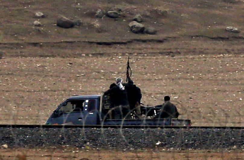 مقاتلون أكراد في سوريا، يقومون بدورية على طول الطريق الحدودي في ضواحي غرب كوباني، سوريا، خلال القتال بين الأكراد السوريين ومسلحي داعش، الجمعة، 17 أكتوبر، 2014. 