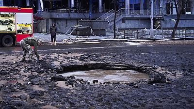 A Ukrainian serviceman collects evidence following a Russian missile attack in Kyiv, Ukraine, Saturday, Jan. 18, 2025.