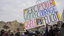 FILE: A man holds a placard reading "Thank you for your courage Gisele Pelicot" outside the Avignon courthouse, southern France, Thursday, Dec. 19, 2024.